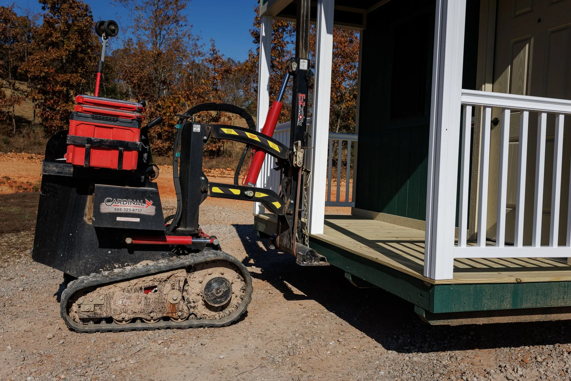 Close-up of the tracked mover lifting the porch end of a Hawthorn cabin