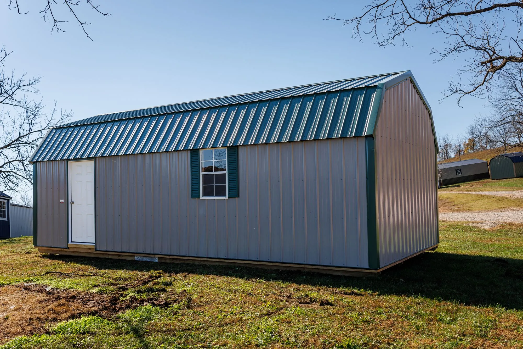 Lofted Garage with gray metal siding with green trim and roof, on the Hawthorn lot in Rocky Comfort, Missouri
