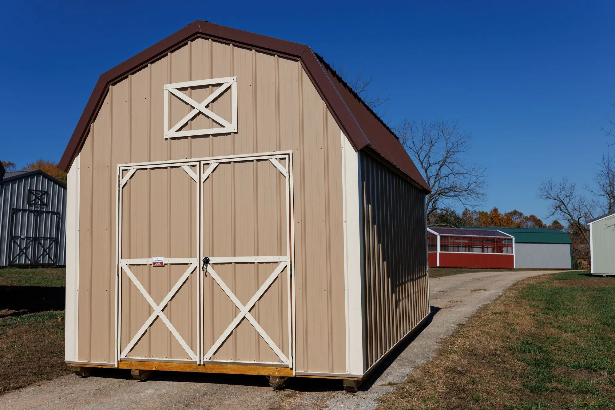 Lofted Barn with tan metal siding, white trim, brown roof, on the Hawthorn lot in Rocky Comfort, Missouri