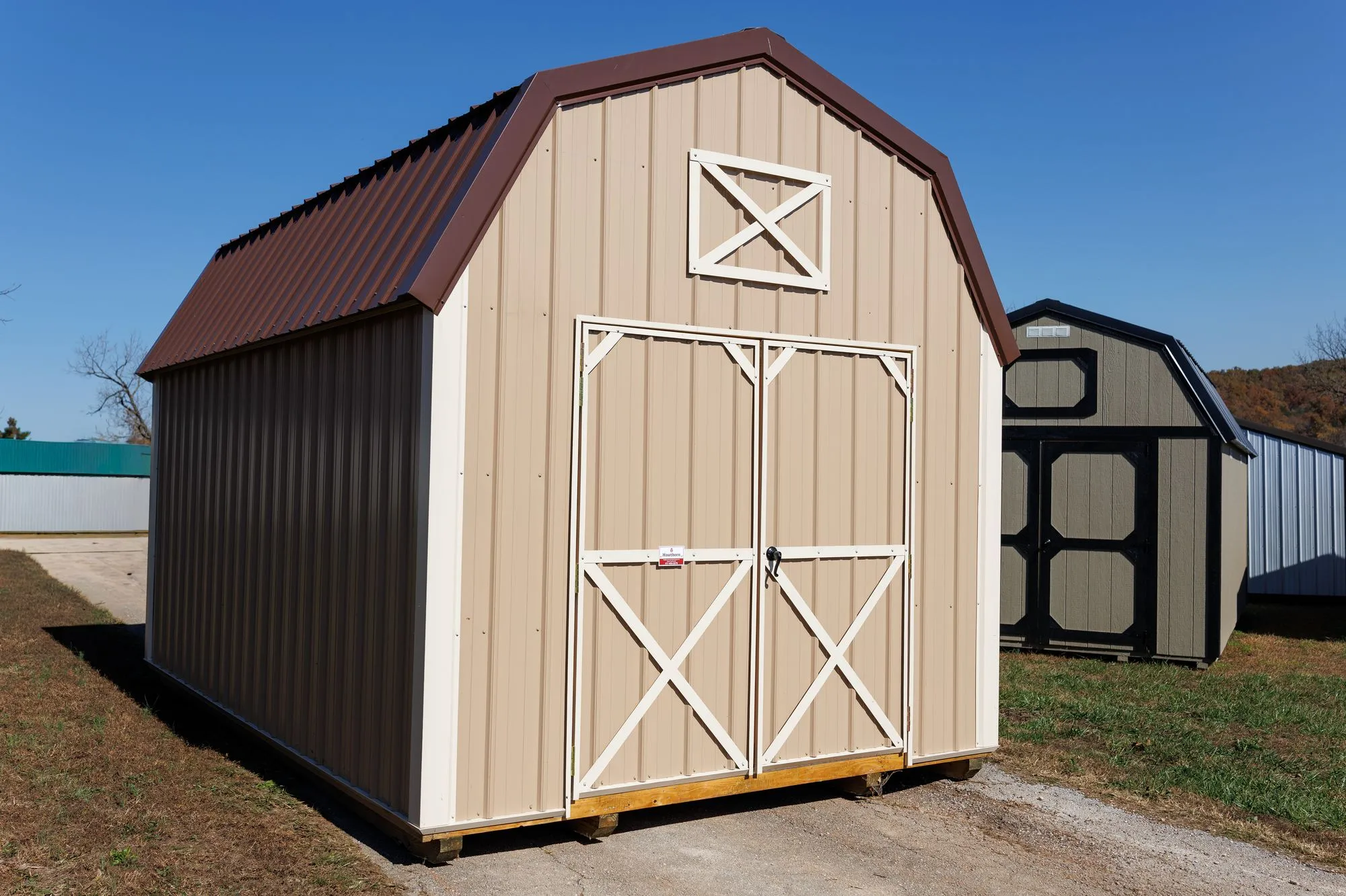 Lofted Barn with tan metal siding, white trim, brown roof, on the Hawthorn lot in Rocky Comfort, Missouri