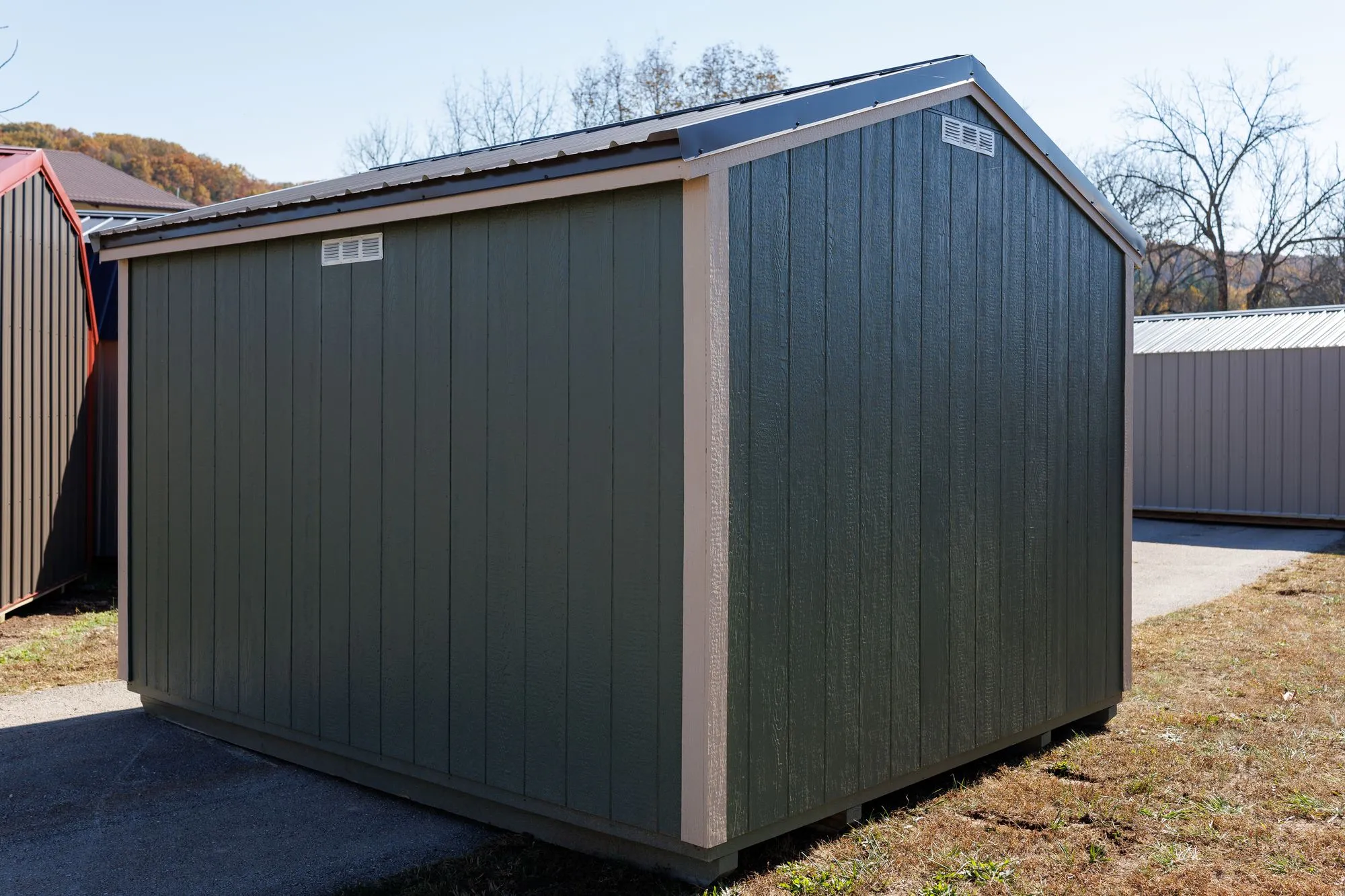 Garden Shed with sage siding, cream trim, black roof, cream-framed doors, on the Hawthorn lot in Rocky Comfort, Missouri