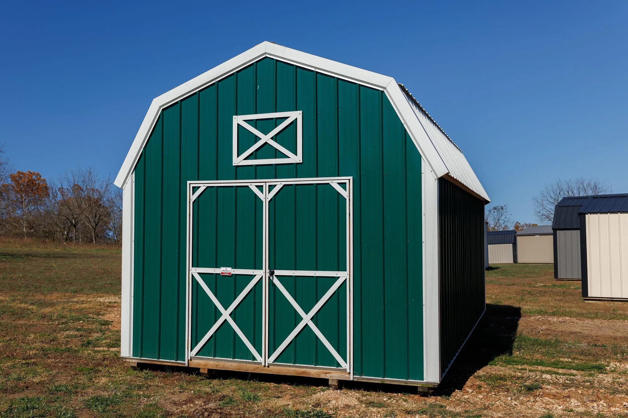 Lofted Barn with green metal siding with white trim, on the Hawthorn lot in Rocky Comfort, Missouri