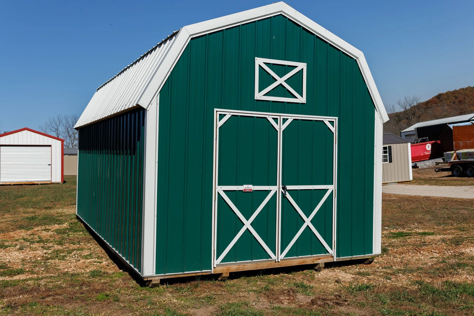 Lofted Barn with green metal siding with white trim, on the Hawthorn lot in Rocky Comfort, Missouri