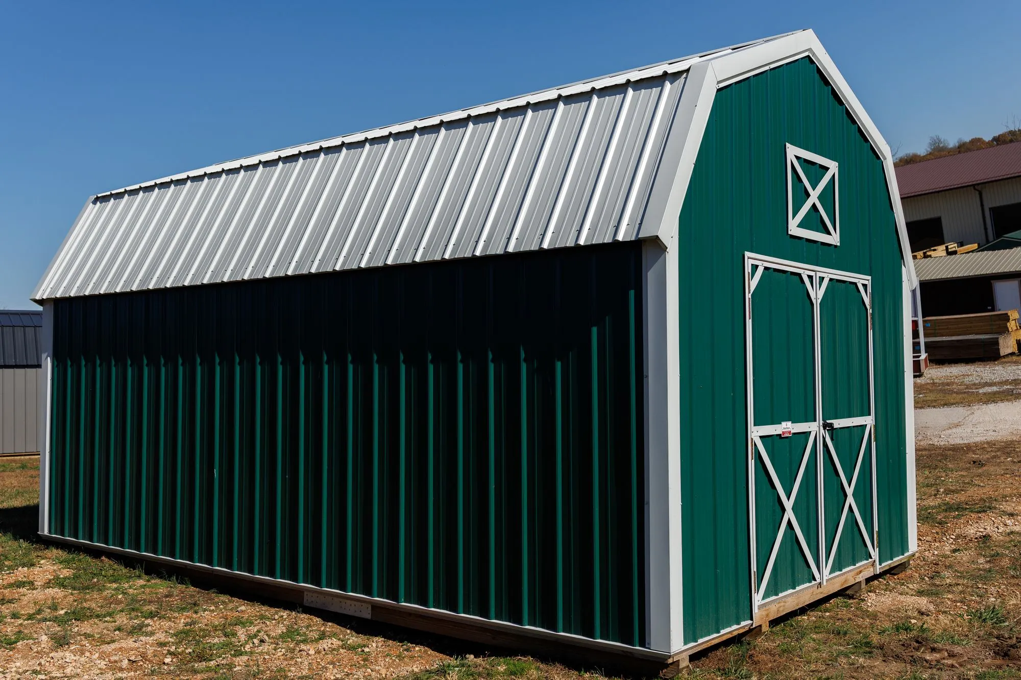 Lofted Barn with green metal siding with white trim, on the Hawthorn lot in Rocky Comfort, Missouri