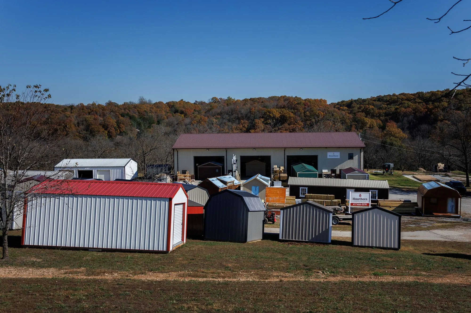 Hawthorn buildings lined up in front of the shop and sign on the lot in Rocky Comfort, Missouri